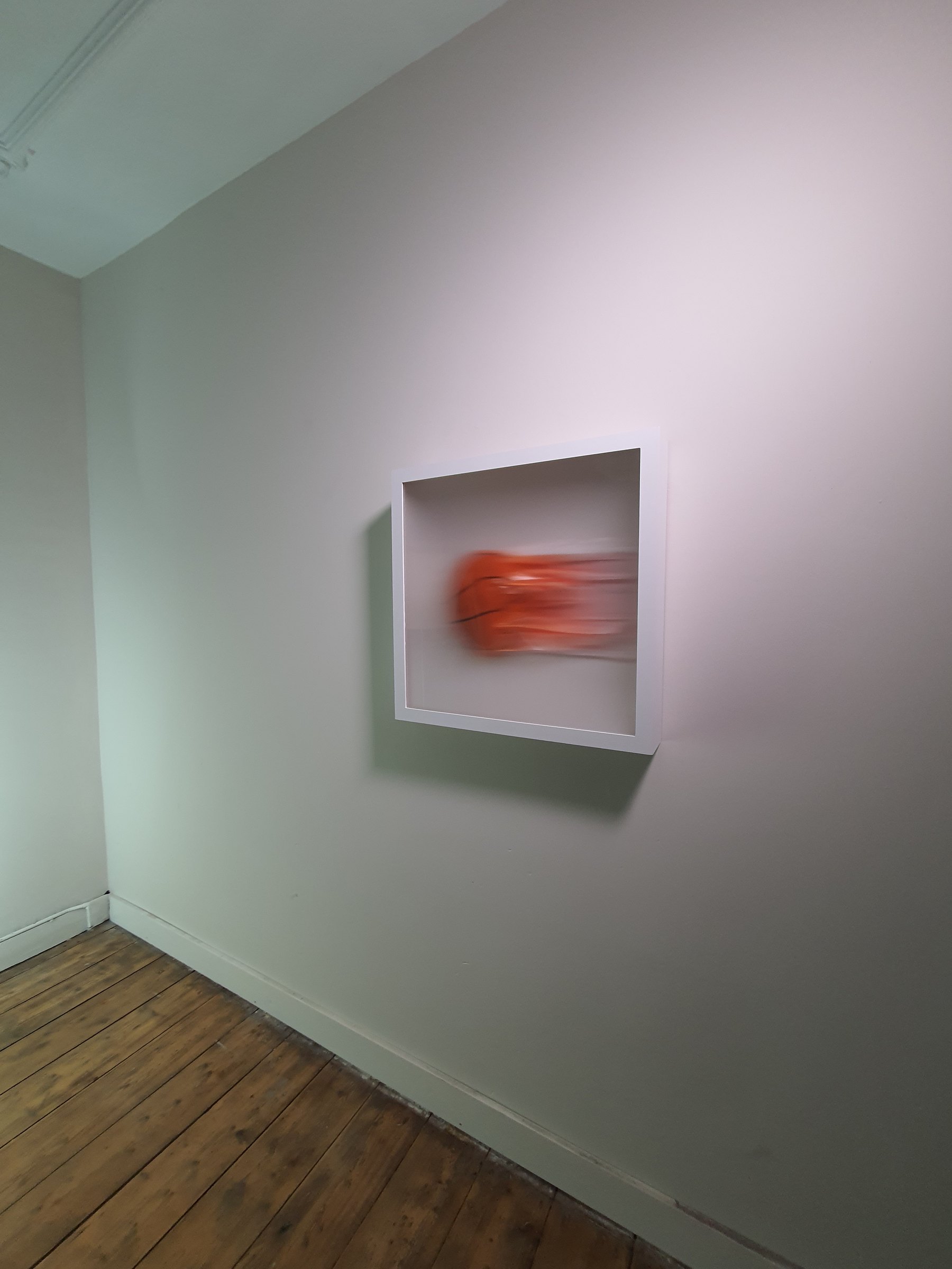 Red motion work installed high on a wall