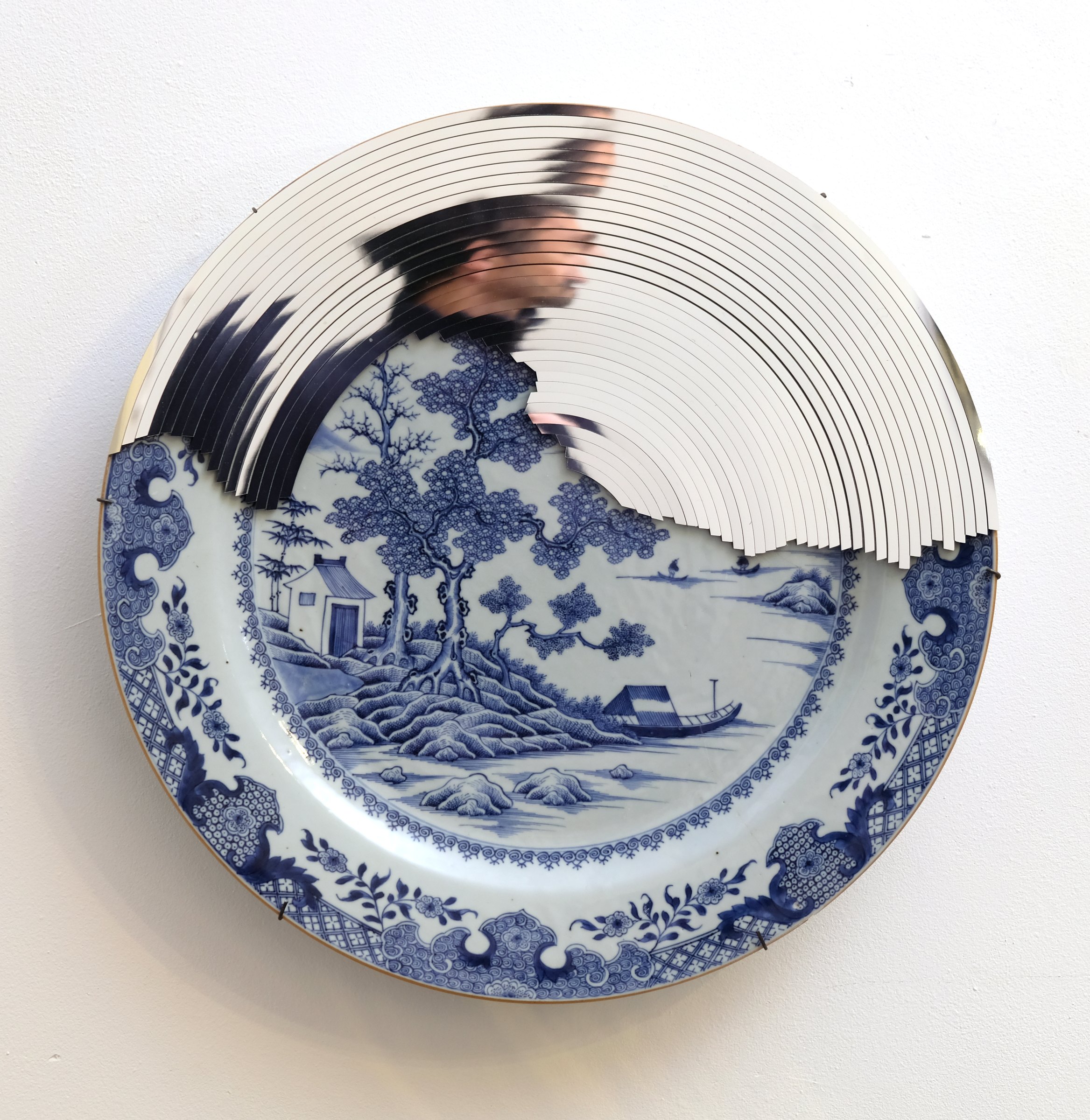 Blue and white porcelain plate interrupted by a concentric mirror