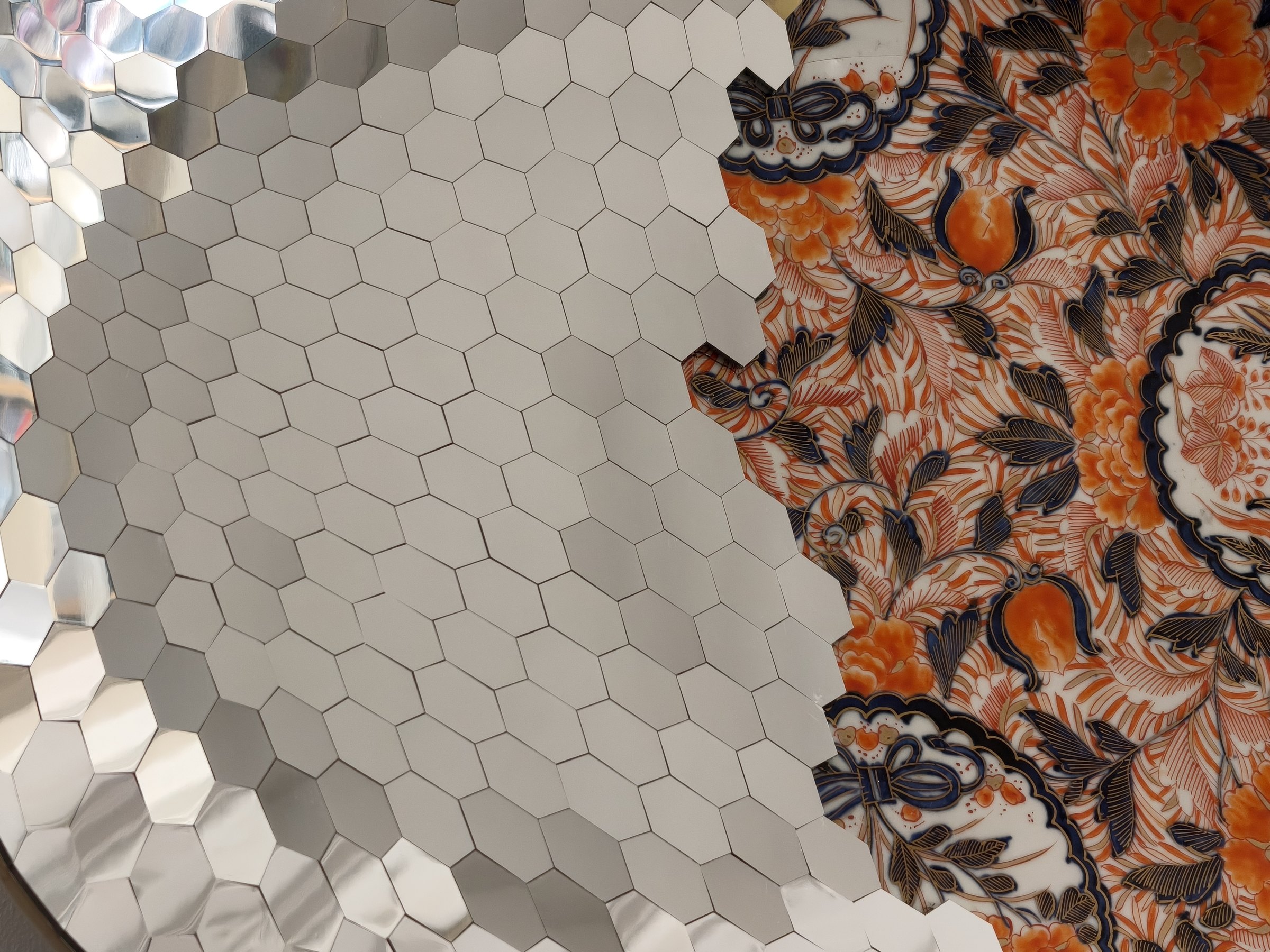 Detail of mirrored hexagons alongside Imari porcelain